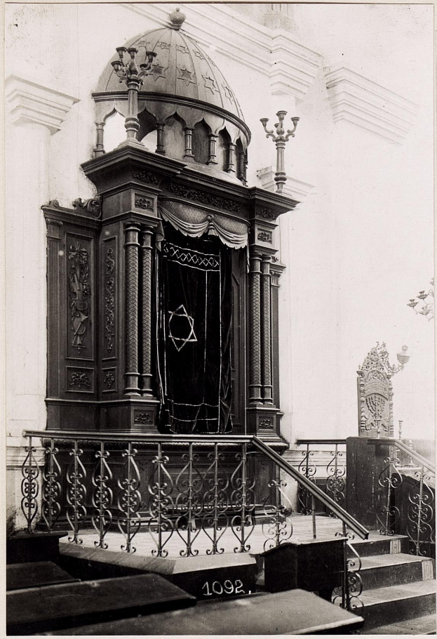 Schwarzes und weißes Foto einer jüdischen Synagoge in New York City mit Treppen, Geländern, Säulen, einer Tür und einer Wand.
