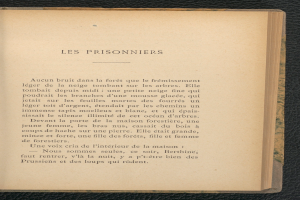 Ein aufgeschlagenes Buch mit den Worten "Les Prisonniers" auf dem Cover, das auf einer schwarzen Oberfläche liegt.