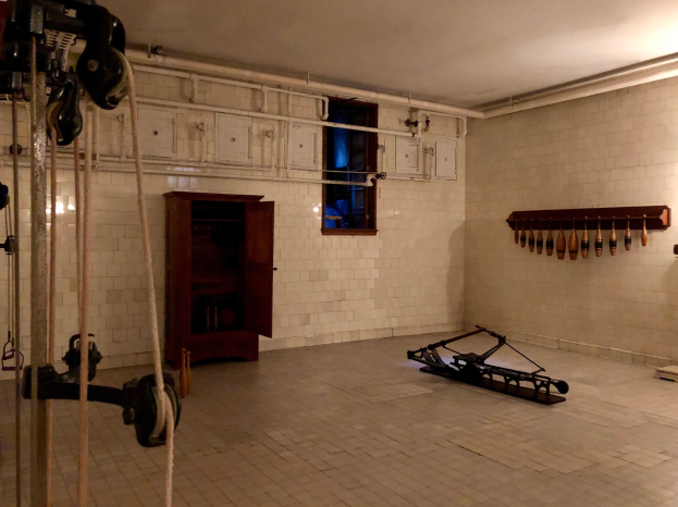 Ein unordentlicher Raum im ehemaligen St. Louis-Gefängnis mit Seilen, Maschinen und anderem Equipment, einem Schrank, einem Fenster und einer Deckenlampe.