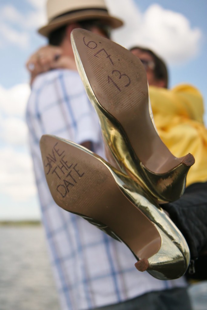 Frauenabsätze mit Text darauf, mit einer Person im Hintergrund, die eine Frau an der Taille hält.