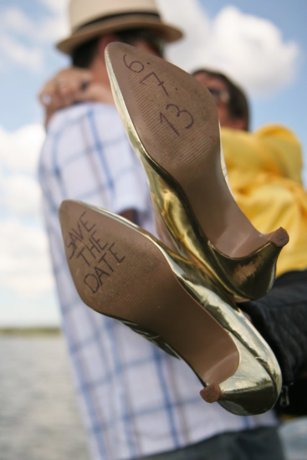 Frauenabsätze mit Text darauf, mit einer Person im Hintergrund, die eine Frau an der Taille hält.