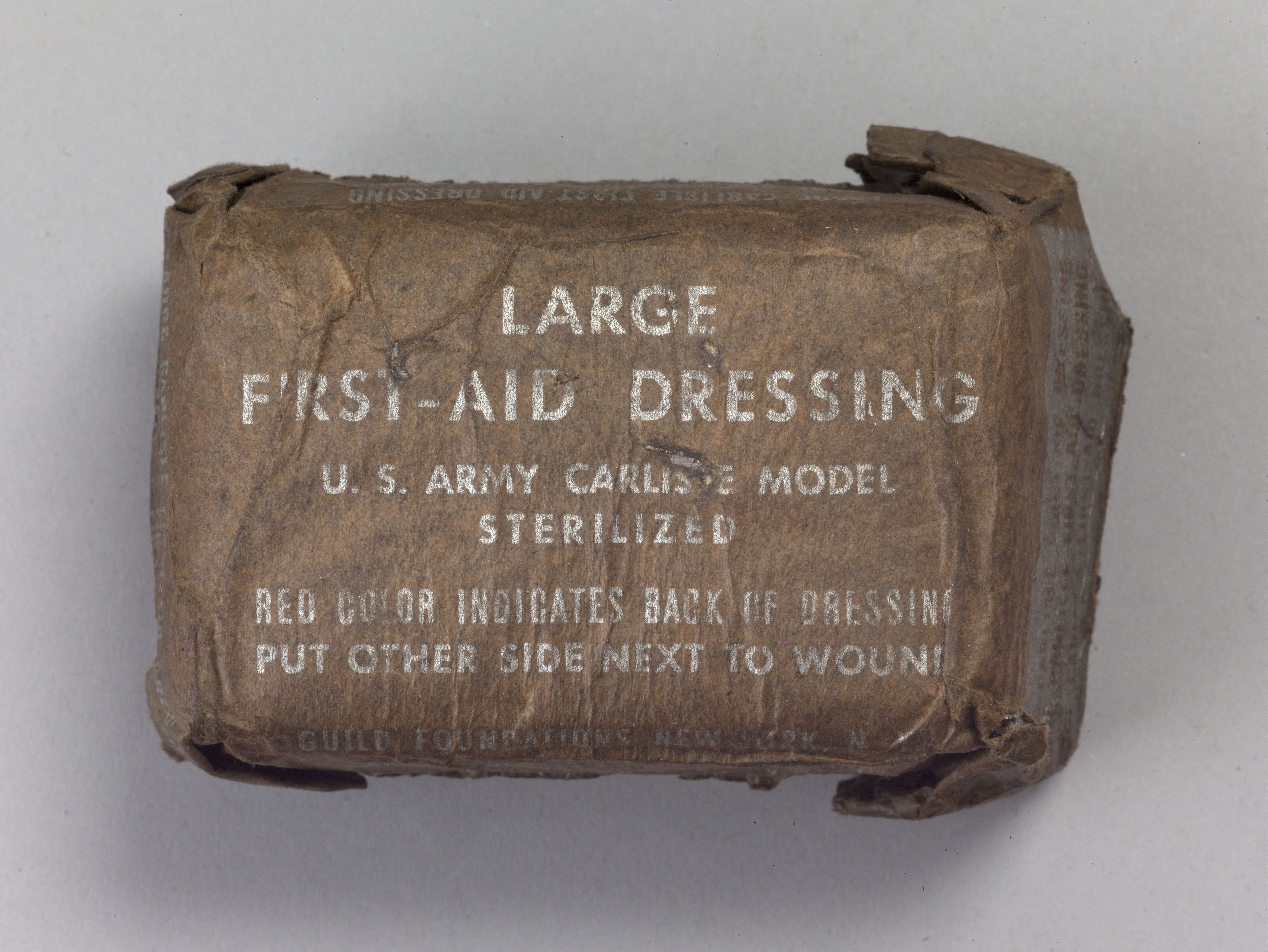 Großer rechteckiger Verbandkasten mit leicht geöffnetem Deckel, beschriftet mit "Großer Verbandkasten" in fetter schwarzer Schrift.