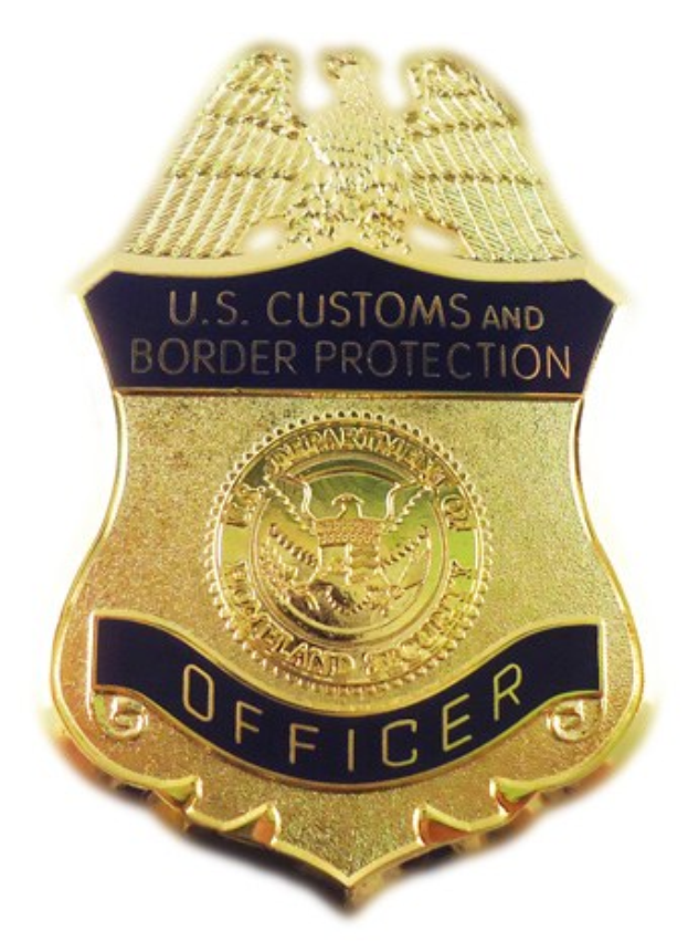 Goldene Marke mit 'U.S. Customs and Border Protection Officer' eingraviert, vor weißem Hintergrund.