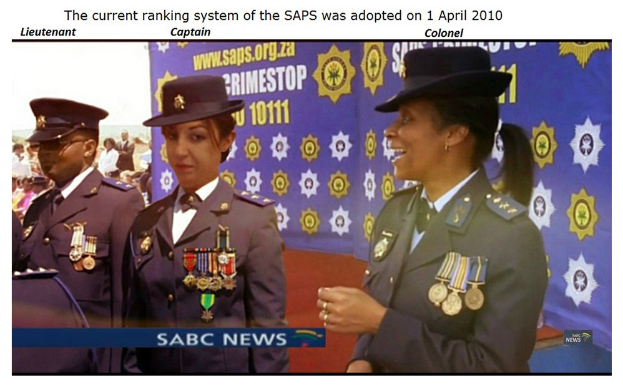 Gruppe von Menschen in Uniformen und Hüten vor einem Banner mit Text oben und unten, der das SAP-Ranking-System-Adoptionsdatum angibt.