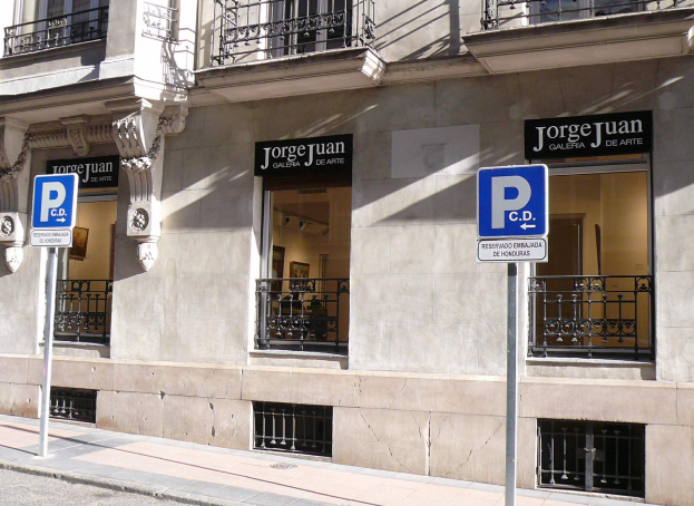 Ein mehrstöckiges Gebäude mit Fenstern, Geländern, Türen und Säulen, das Werbetafeln auf Pfählen entlang des Gehwegs und sichtbare Innenobjekte zeigt, die eine belebte Stadtkulisse suggerieren.