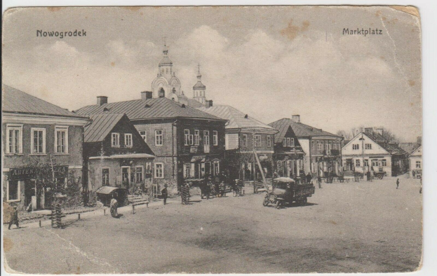 Schwarz-weiß-Foto einer Stadtstraße in Nowogrodeek, Deutschland, mit Gebäuden, Menschen, Wagen, Pfählen, Bäumen und Himmel, mit dem Text "Marktplatz in Nowogrodeek, Deutschland" oben und unten.