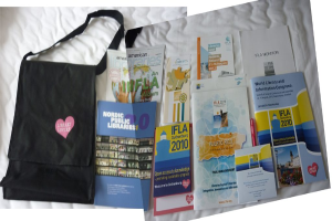 Eine Tasche mit der Aufschrift 'Bibliotheksliebhaber' und einige Bücher auf einem Bett.