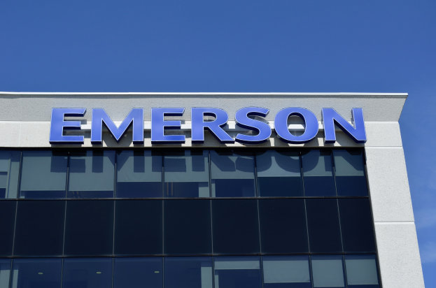 Emerson-Logo an einer Gebäudefassade mit dem Text '1,5 Milliarden US-Dollar Investition' unter einem klaren blauen Himmel.