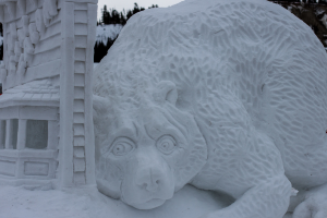 Schneekunst im Vordergrund mit ein paar Bäumen und einem Himmel im Hintergrund.