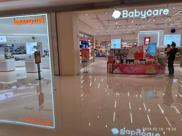 Ein Babyladen in einem Einkaufszentrum mit Menschen, Spielzeugen, Regalen, Schildern, einem Anzeigebildschirm, Deckenlampen und einem Dach, das sich im Mall of Asia befindet.