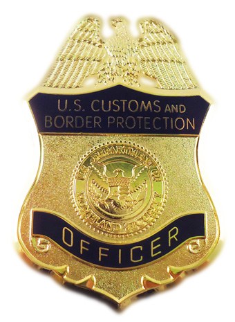 Goldenes Abzeichen mit der Aufschrift "U.S. Customs and Border Protection Officer" auf weißem Hintergrund.