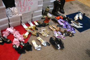 Schuhe befinden sich in der Mitte des Bildes auf einem Teppich, mit Kisten, die an der oberen Seite des Bildes positioniert sind.