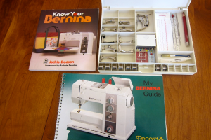 Zwei Bücher und eine offene Werkzeugkiste mit Werkzeugen darin sind auf einem Tisch placed.