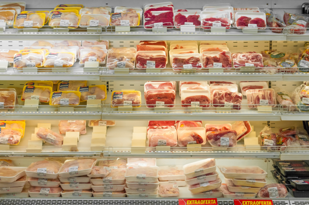 Ein gut organisierter Supermarktboden mit verschiedenen Arten von ordentlich sortiertem Fleisch mit angehängten Preisschildern.