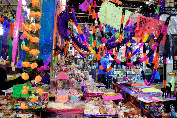 Ein belebter Markt mit Ständen, die Spielzeug, Dekorationsgegenstände und andere Gegenstände verkaufen, Menschen, die herumlaufen, und Deckenbeleuchtung.